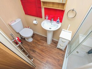Ein kleines Badezimmer mit Toilette, Waschbecken und Stauraum.
