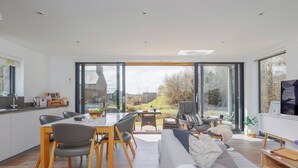 A modern kitchen with a dining area, a sofa, and a TV. - 3 bedroom accommodation in Dorchester (Dorchester)