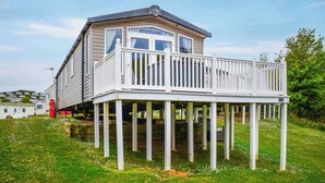 Ein zweistöckiges Haus mit Balkon, Garage und einem roten Gasflaschen.