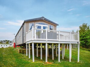 Ein zweistöckiges Haus mit Balkon, Garage und einem roten Gasflaschen.