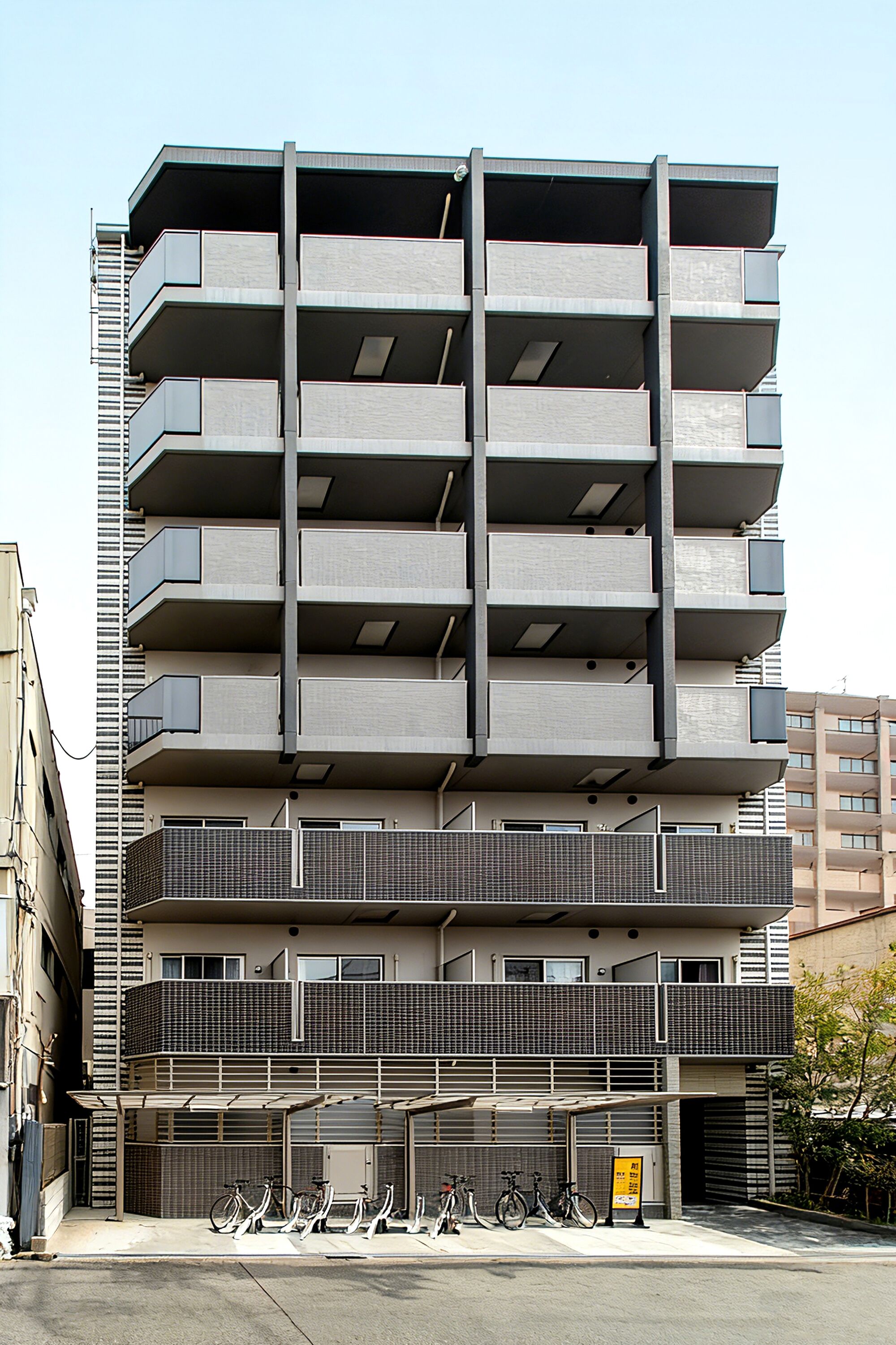 Un parking à étages doté de plusieurs balcons et d’un espace abrité pour le stationnement des vélos.