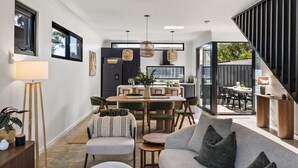 Un interior moderno con comedor, sofá y escalera.