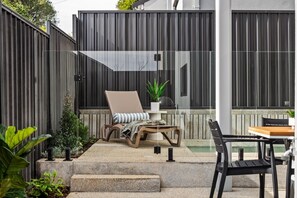 A patio with a lounge chair, a small table, and a potted plant. - Stone River Villa 3 | Relaxed Stay | Heated Pool (Margaret River)