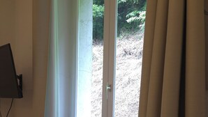 A room with a window, a desk, and a chair. - Charming studio in the heart of uriage (saint martin d'uriage)