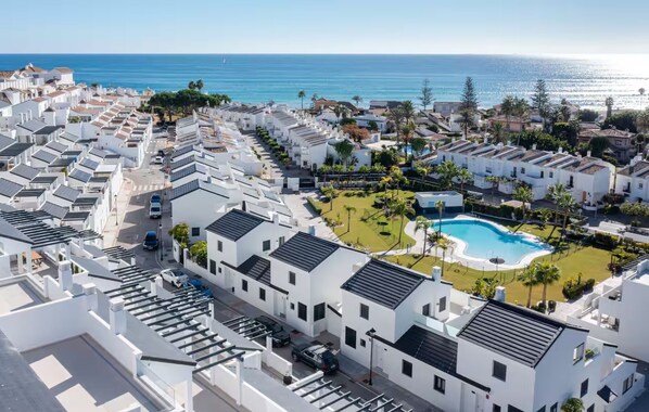 A coastal residential area with modern white buildings, a swimming pool, and a view of the sea. - Solmare, Coastal Comfort in Estepona (Estepona)