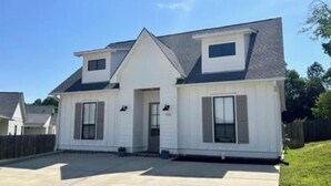 A two-story house with a front porch, a garage, and a small attached garage.