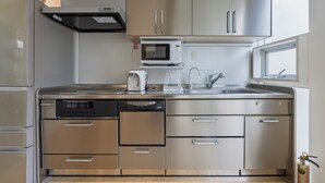 Una cocina moderna con electrodomésticos de acero inoxidable, lavavajillas y microondas.