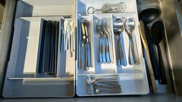 A drawer with neatly organized cutlery including forks, spoons, and knives.