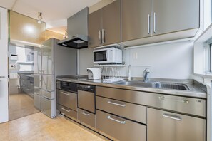 Una cocina moderna con electrodomésticos de acero inoxidable, lavavajillas y microondas.