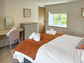 Ein Hotelzimmer mit Bett, Schreibtisch, Stuhl, Kleiderschrank und einem Fenster mit Blick.