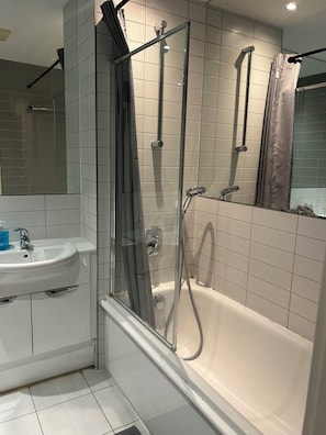 Ein Badezimmer mit Dusche, Waschbecken und Badewanne.