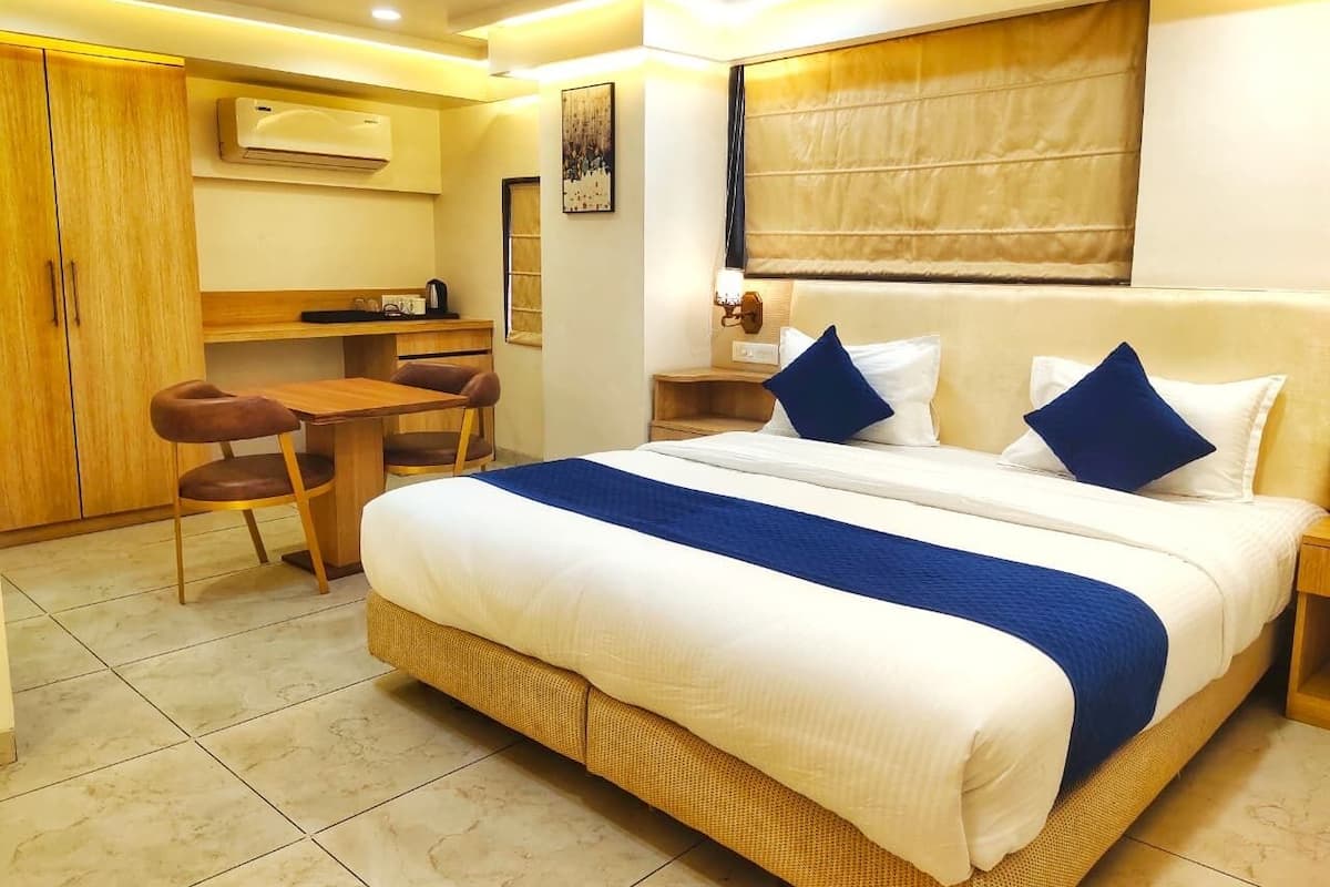 Una habitación de hotel con una cama grande, un escritorio y una silla.