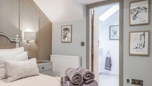 Ein Schlafzimmer mit einem Bett, einem Heizkörper und Bildern an den Wänden.