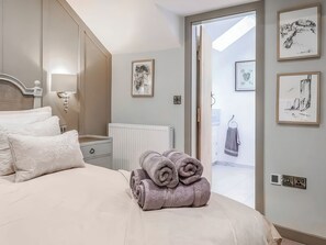 A bedroom with a bed, a radiator, and artwork on the walls. - 1 bedroom accommodation in Conwy (Conwy)