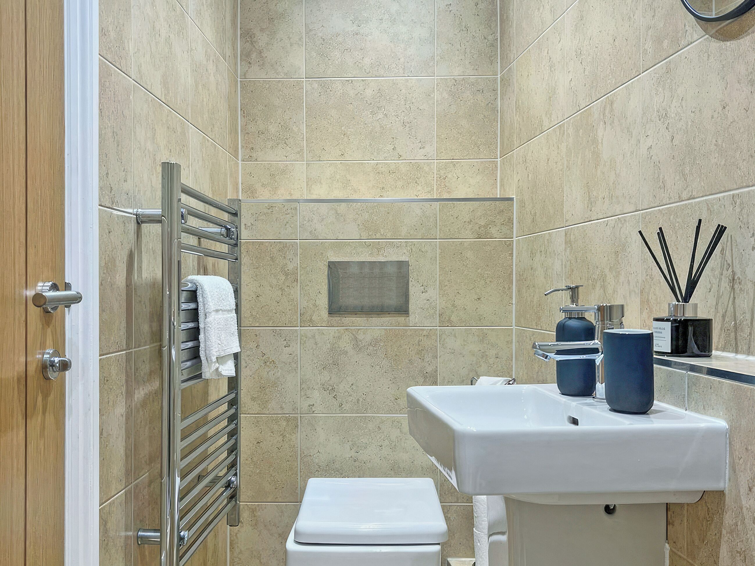 A bathroom with a shower, a toilet, a sink, and a towel rack.