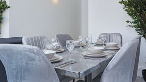 Een eethoek met een rechthoekige tafel voor zes personen, omringd door grijze gestoffeerde stoelen.