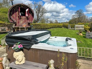 Ein Whirlpool mit einer Holterrasse, einer verzierten Kopfsulptur und einer Überdachung mit Schornstein.