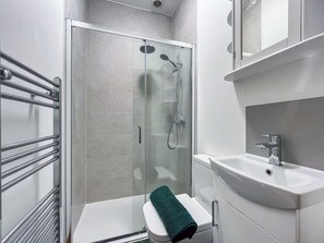 A modern bathroom with a glass-enclosed shower, a white sink, and a towel rack. - 4 bedroom accommodation in Scarborough (Scarborough)