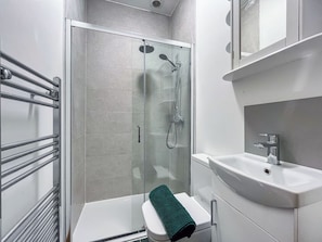 A modern bathroom with a glass-enclosed shower, a white sink, and a towel rack. - 4 bedroom accommodation in Scarborough (Scarborough)