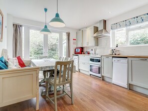 A kitchen with a dining table, chairs, and a view of the outdoors. - Bembridge Coastal Escape (Bembridge)