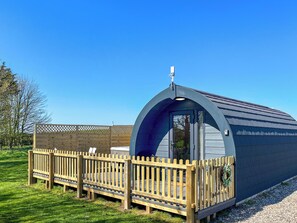 A small, single-story building with a curved roof and a wooden deck. - 1 bedroom accommodation in Humanby, near Filey (Humanby, near Filey)