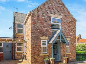 A brick house with a gabled roof, a front door, and a satellite dish. - Old Master's Cottage (Leven)