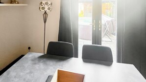 Ein Zimmer mit Bett, Schreibtisch, Stuhl, Lampe und Blick durch eine Tür.