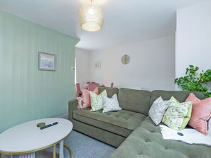 A living room with a green sofa, a round coffee table, and a hanging light fixture. - 2 bedroom accommodation in Staindrop, near Barnard Castle (Staindrop, near Barnard Castle)