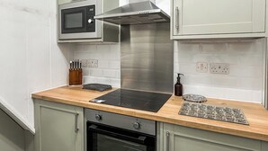 A kitchen with a microwave, stove, oven, and a wooden countertop. - A Cosy two bedroom cottage, perfectly located in Bamford. (Bamford)