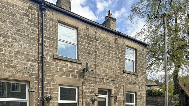 A stone building with multiple windows, a door, and a small bench outside. - A Cosy two bedroom cottage, perfectly located in Bamford. (Bamford)