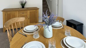 A dining table set with plates, cutlery, and a vase with lavender. - A Cosy two bedroom cottage, perfectly located in Bamford. (Bamford)