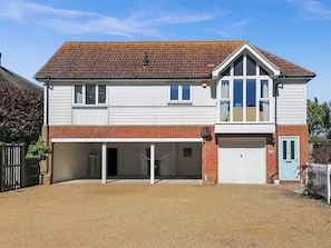 Ein zweistöckiges Haus mit Garage, Satellitenschüssel und Ziegel Fassade.