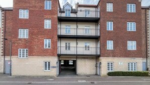 A multi-story building with a brick facade, multiple balconies, and a ground-level entrance. - Abbey Lights - UK51880 (Whitby)