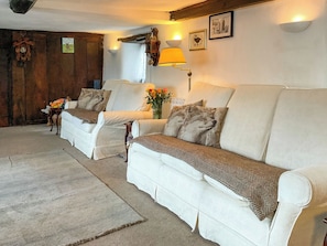 A cozy living room with a sofa set, a wooden door, a wall-mounted lamp, and a framed picture. - 2 bedroom accommodation in Barrington, near Ilminster, (Barrington, near Ilminster,)