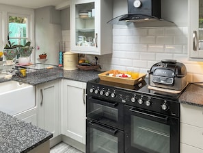 A modern kitchen with white cabinetry, a black stove, and a built-in oven. - 2 bedroom accommodation in Barrington, near Ilminster, (Barrington, near Ilminster,)
