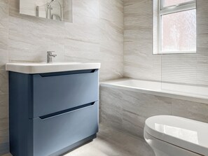 A bathroom with a modern sink, a toilet, and a bathtub.