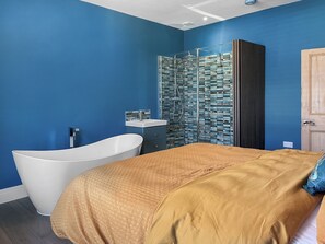 Une salle de bain moderne avec une baignoire sur pieds, une douche à parois de verre et une armoire en bois.