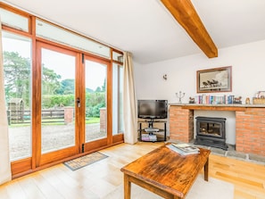 A living room with a fireplace, a television, and a bookshelf. - The Barn Cottage - UK51885 (Grimblethorpe)