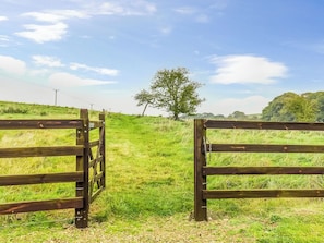 A wooden gate in a grassy field with a tree in the background. - The Barn Cottage - UK51885 (Grimblethorpe)