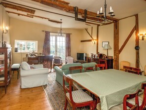 Ein gemütliches Zimmer mit einem Klavier, einem Esstisch und einem Fernseher.