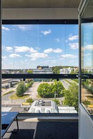 Una habitación con un ventanal grande que ofrece vistas a un paisaje urbano, incluyendo edificios y una carretera.