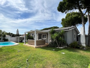 Une maison dotée d’un patio couvert, d’une piscine et d’une pelouse bien entretenue.