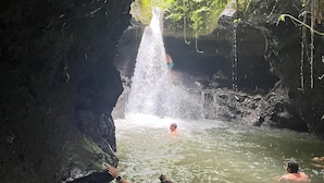 A natural water feature with a waterfall, surrounded by greenery and rocky formations. - Botanika Estate (Tetebatu)