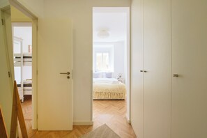 Ein Schlafzimmer mit einem Bett, einem Kleiderschrank und einer Tür zu einem weiteren Raum.