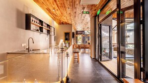 Ein modernes Interieur mit Holzboden, einer Glastheke und einer Sitzecke mit Blick.