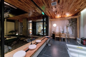A restaurant interior with wooden ceiling, a dining area with a table and chairs, a counter with stools, and a view of the outside. - Luming Courtyard Hotel Xi'an City Wall (Xi'an)