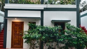 Un edificio moderno con una puerta de madera, una ventana pequeña y una escalera que conduce a la entrada.