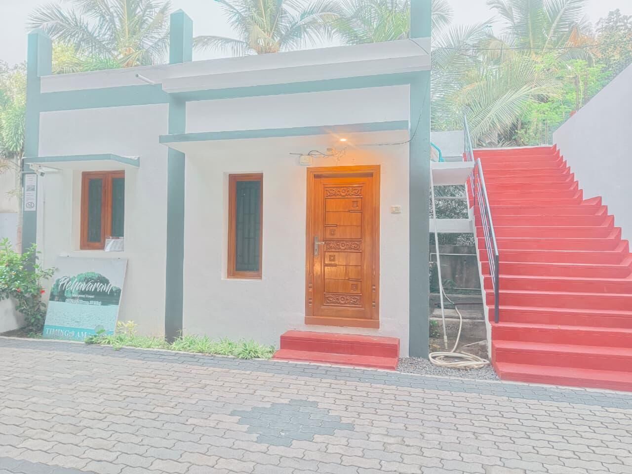 A building with a wooden door, a red staircase, and a signboard.