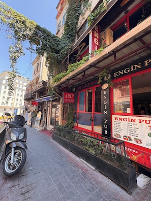 Straßenansicht eines Gebäudes mit Schildern für 'ARIF MUZIKHOL' und 'ENGIN PUB'.