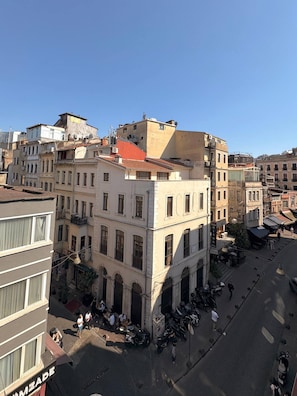 Ein mehrstöckiges Gebäude mit Innenhof, Balkonen und einer Straße davor.